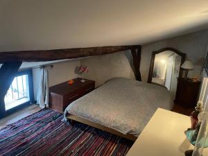 a bedroom with a bed and a large window at Maison de caractère in Les Bordes-sur-Arize