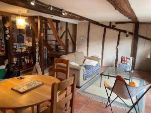 a living room with a table and a couch at Maison de caractère in Les Bordes-sur-Arize