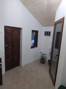 a hallway with a wooden door and a plant at Casuta din Livada 3 in Drăganu-Olteni