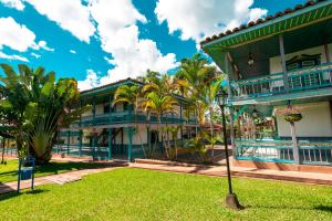 un edificio con palmeras delante en Decameron Las Heliconias - All Inclusive, en Quimbaya