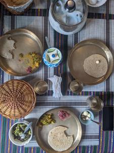 a table topped with plates of food on a table at Nalze Khar in Raogi