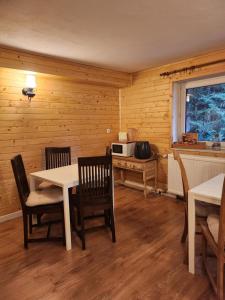 a dining room with a table and chairs and a microwave at Uroczysko pod Babią Górą in Zawoja +25 photos