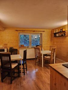 a dining room with tables and chairs and a window at Uroczysko pod Babią Górą in Zawoja