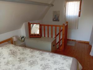 a bedroom with a bed and a mirror and a staircase at La Maisonnette - animaux acceptés, parking privé, jardin plein sud in Wissant