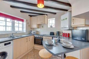 a kitchen with a table and a sink and a dishwasher at 2 Bed in Wangford oc-8hsw in Wangford