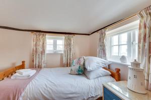 a bedroom with a bed and two windows at 2 Bed in Wangford oc-8hsw in Wangford