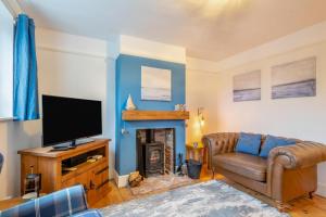 a living room with a tv and a couch and a fireplace at 3 Bed in Kessingland oc-b27635 in Kessingland