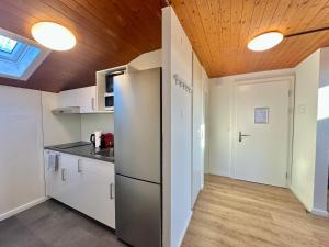 a kitchen with white cabinets and a wooden ceiling at Monteurzimmer - Worker's accommodation - ZIMMERzuVERMIETEN in Deitingen Neumatt in Deitingen +16 photos