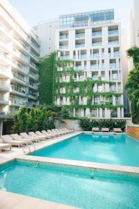 a swimming pool with chairs and a building at CasaSur Bellini in Buenos Aires