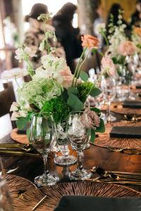 a table with a vase of flowers and wine glasses at Polylepis Lodge in El Ángel