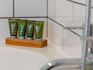 a row of green cups on a wooden shelf next to a sink at 4 Bed in Bridport oc-dc083 in West Bay +33 photos