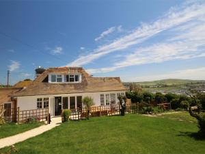 a house with a green lawn in front of it at 4 Bed in Bridport oc-dc083 in West Bay
