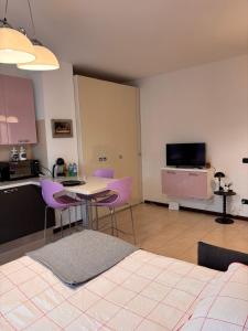 a kitchen with purple chairs and a table in a room at Casa San Martino 21 in Uboldo