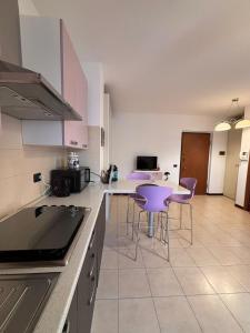 a kitchen with purple chairs and a counter top at Casa San Martino 21 in Uboldo