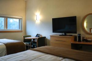 a hotel room with a flat screen tv and a bed at Prince Conference Center & Hotel in Grand Rapids