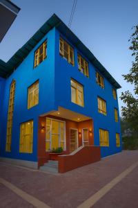 a blue house with yellow doors and windows at THE NUN KUN Pahalgam in Pahalgām