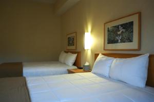 a hotel room with two beds with white pillows at Prince Conference Center & Hotel in Grand Rapids +1 photo