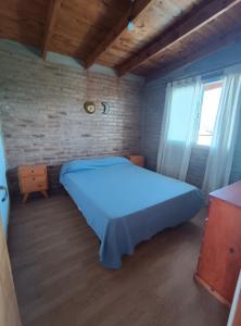 a bedroom with a blue bed in a brick wall at La Posada De Vito in Córdoba +37 photos