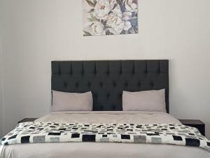 a bedroom with a large bed with a black headboard at 19 on Smit in Piet Retief