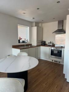 a kitchen with a table and a counter top at 2 Bed apartment- Laindon in Great Burstead +1 photo