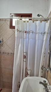 a bathroom with a shower curtain and a sink at MONOAMBIENTE Flores del Cielo in Federación +6 photos