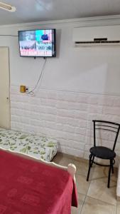 a bedroom with a bed and a tv on the wall at MONOAMBIENTE Flores del Cielo in Federación