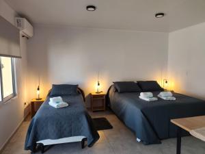 a bedroom with two beds and two tables and two lamps at Dormis del Sol in Caseros