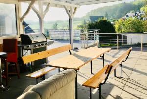 a patio with picnic tables and a grill on a roof at Townhaus Mariaroth in Dieblich