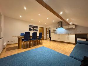 a living room with a table and chairs and a kitchen at Townhaus Mariaroth in Dieblich