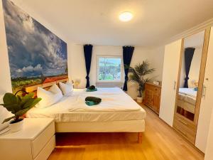 a bedroom with a large bed with a painting on the wall at Townhaus Mariaroth in Dieblich