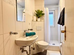 a white bathroom with a sink and a toilet at Townhaus Mariaroth in Dieblich +78 photos