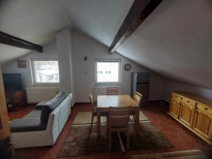 a living room with a table and a couch at Apartmani Ivan in Kupres +5 photos