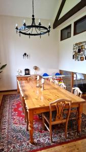 a dining room table with chairs and a chandelier at Wagtail Barn in Ipplepen