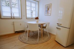 a kitchen with a table and chairs and a refrigerator at Emsperle in Rietberg