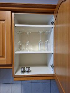 a cupboard with wine glasses in it at Ferienwohnung Veitsch in Niederaigen +7 photos