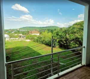 a room with a balcony with a view of a field at Like Residence and 35 Apartment in Suratthani