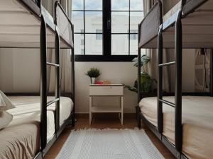 two bunk beds in a room with a desk and a window at Blue Surf House Only surf in Corralejo
