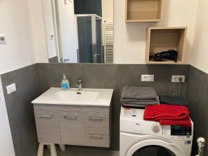 a bathroom with a sink and a washing machine at La Casa di Nives in Scorzè