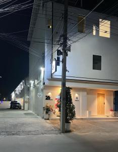a lit up building with a car parked outside at night at 24Rooms นครสวรรค์ in Nakhon Sawan
