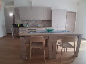 a kitchen with a table with chairs and white cabinets at Posidonia in Lizzano
