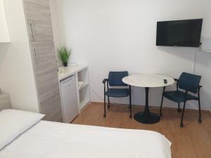 a room with a table and two chairs and a tv at Soba brez balkona in Stara Novalja