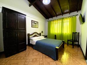 a bedroom with a bed and a green curtain at Hospedaje Casa Real in Salamina