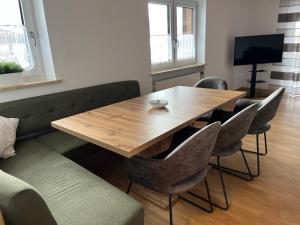 a dining room with a wooden table and chairs at Ferienwohnung zum Breu im Löwen in Reit im Winkl