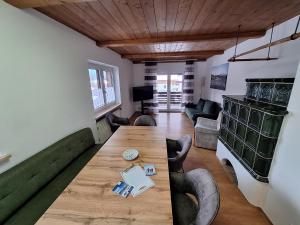 a living room with a wooden table and a couch at Ferienwohnung zum Breu im Löwen in Reit im Winkl