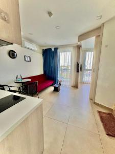 a living room with a red couch and a table at City Garden Olympus condo balcony in Pattaya South