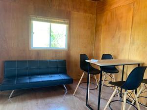 a couch in a room with a table and chairs at L a N e g r a in Barra de Portezuelo