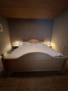 a bedroom with a wooden bed with lights on it at Hyggehuset in Tønder