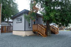 a small house with two decks and a tree at Cozy 2 Bedroom Cabin in Sunshine Valley