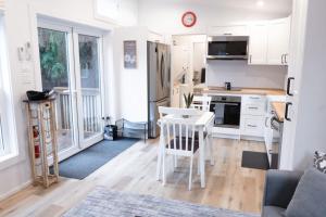 a kitchen with white cabinets and a table and chairs at Cozy 2 Bedroom Cabin in Sunshine Valley +14 photos