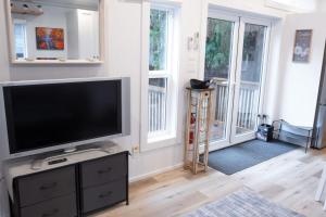a living room with a flat screen tv and windows at Cozy 2 Bedroom Cabin in Sunshine Valley